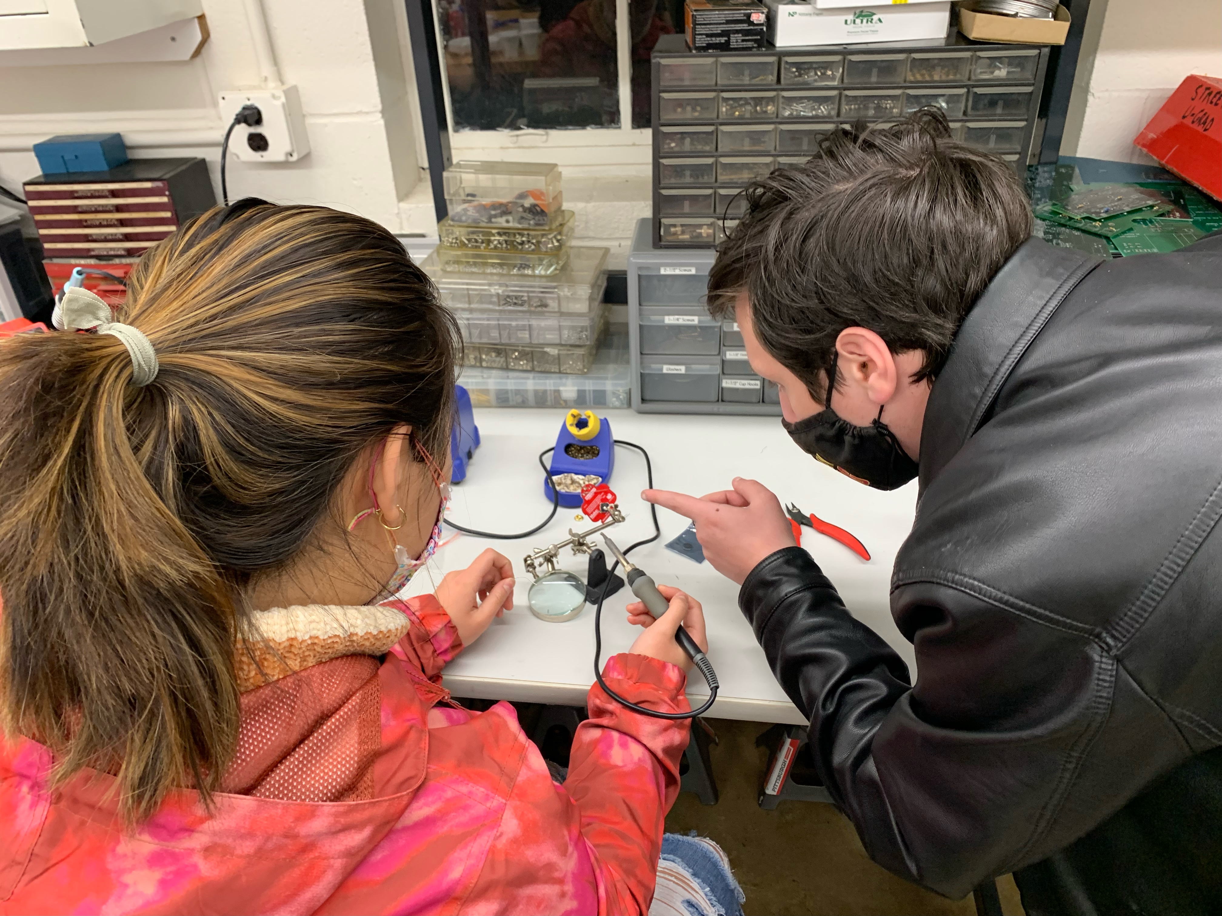 Jake Lyon (right) teaches a student how to solder a simple circuit at the UMD Physics Vortex Makerspace.