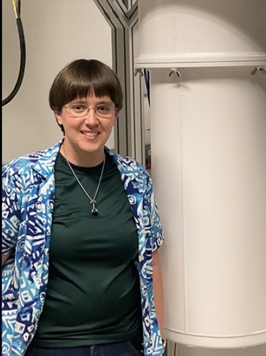 Alicia Kollár standing next to a dilution refrigerator in her lab. (Credit: Alicia Kollár)