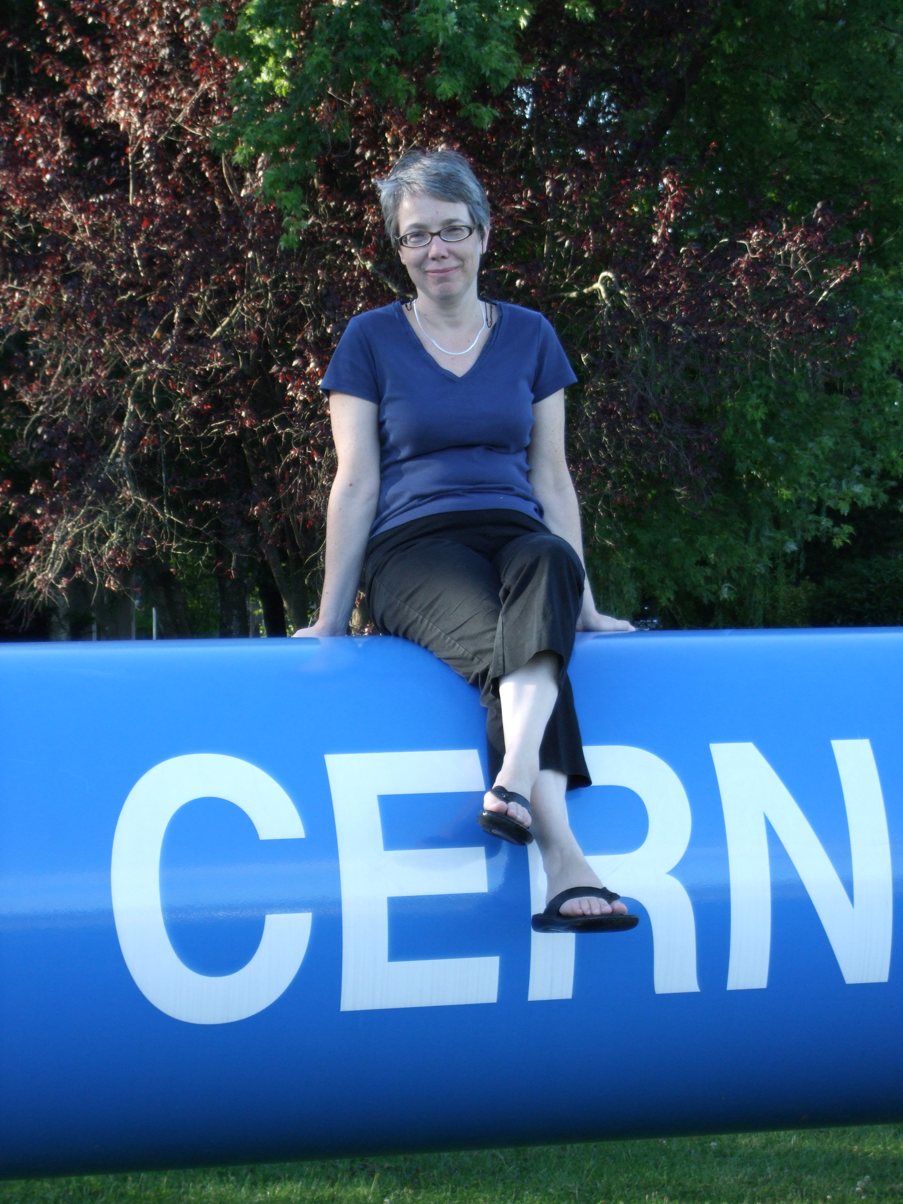 Sarah Eno, a physics professor at UMD, sits atop a model of a Large Hadron Collider (LHC) dipole magnet at CERN about 10 years ago. At the time, she was participating in LHC experiments and frequently spent her summers at the lab in Switzerland. Credit: Meenakshi Narain.