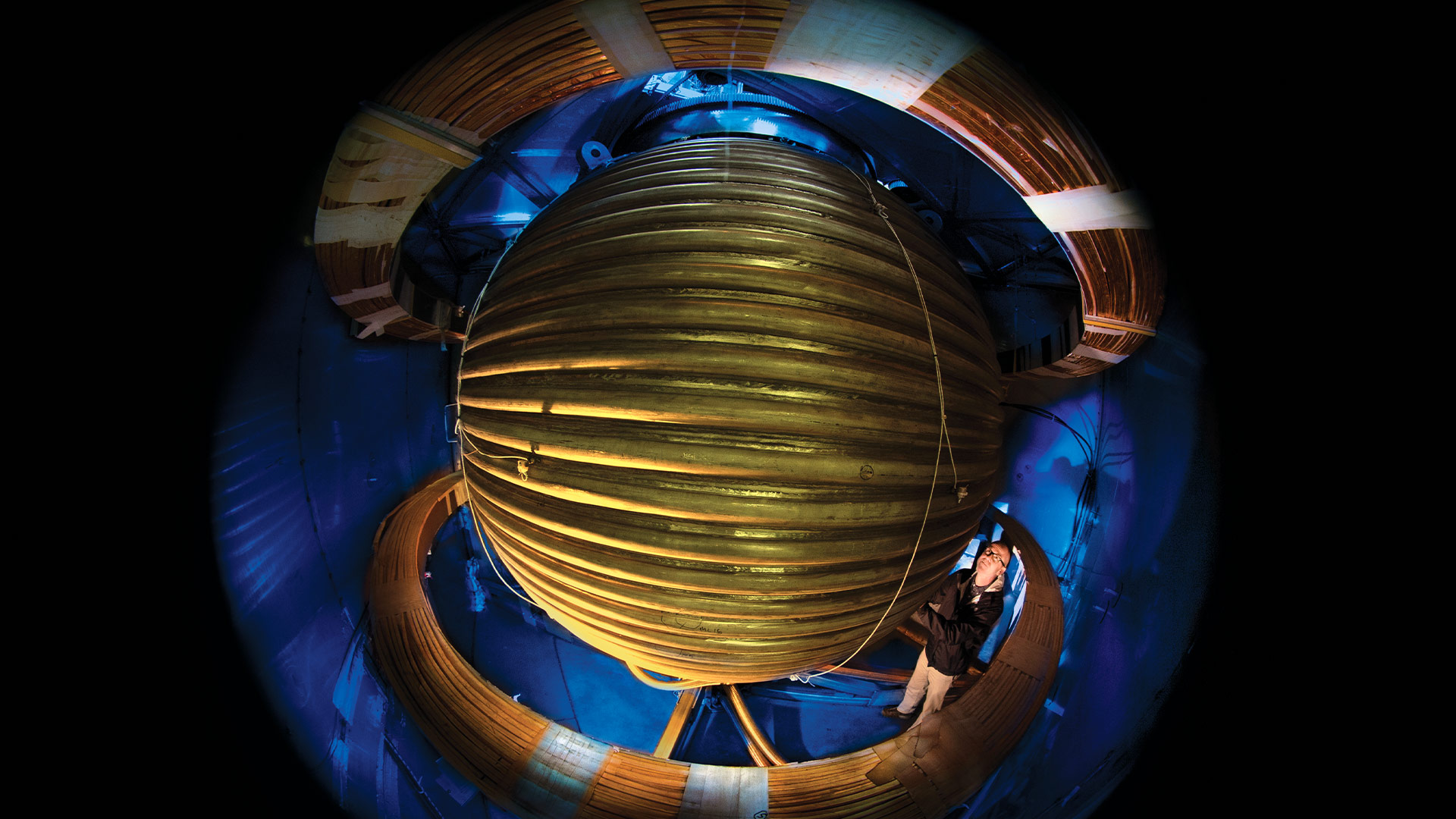 Professor Dan Lathrop examines the 3-meter steel sphere he uses in simulations of the Earth's "geodynamo." Hidden inside the spinning outer sphere (diagram, below) molten sodium and an even quicker-whirling inner sphere represent the earth's liquid outer core and solid inner core, which create geomagnetism. (Photo by John T. Consoli; diagram by Kolin Behrens)