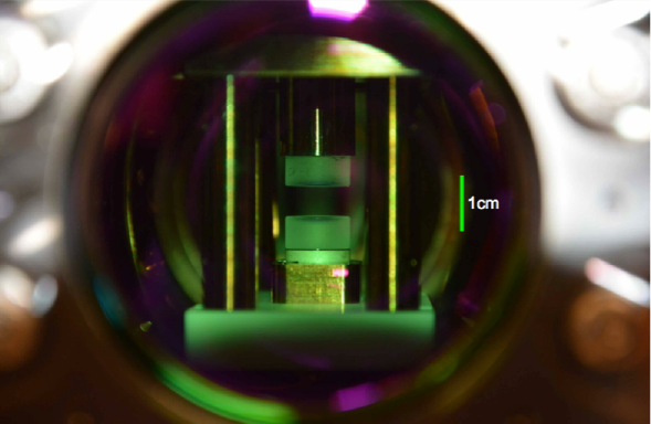 Mirrors with a green tint can be seen inside a small experimental cavity.